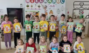 Dzieci trzymające prace plastyczne z wielkanocnymi króliczkami.
