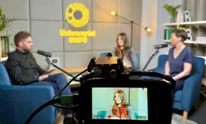 Nagranie rozmowy trzech osób w studiu z logo SWPS w tle.