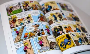 Otwarta książka z kolorowymi ilustracjami komiksowymi, przedstawiającymi postacie i zwierzęta.