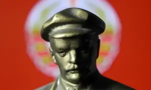 Popiersie mężczyzny w czapce na tle czerwono-białego okręgu.