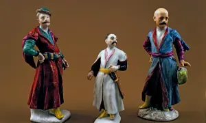 Trzy porcelanowe figurki szlachciców w strojach sarmackich.