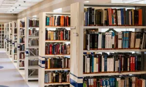 Rzędy regałów z książkami w bibliotece.