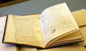 Otwarta księga z ręcznie pisanym tekstem w języku polskim, widoczny podpis.