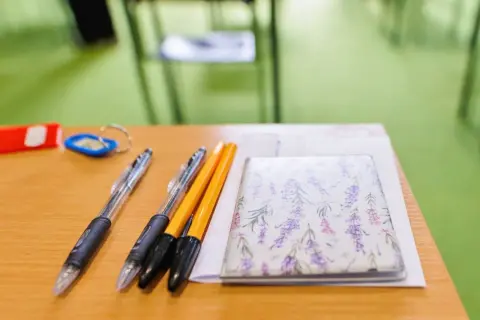 Długopisy i notes z lawendą na drewnianym biurku.