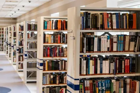 Rzędy regałów z książkami w bibliotece.