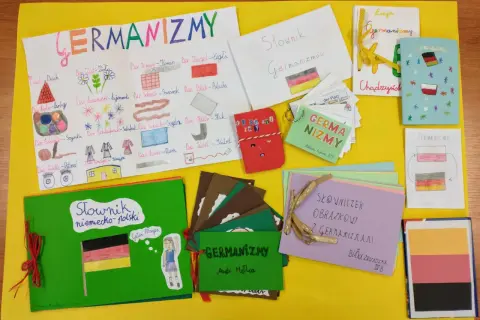 Kolorowa wystawa prac plastycznych i słowniczków na temat germanizmów w języku polskim.