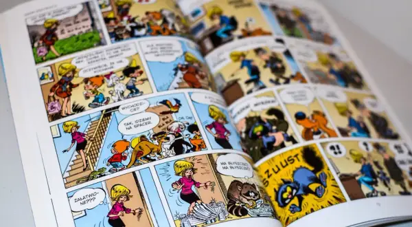 Otwarta książka z kolorowymi ilustracjami komiksowymi, przedstawiającymi postacie i zwierzęta.