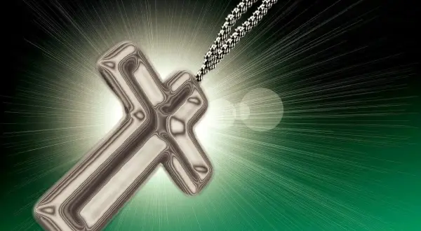 Metalowy krzyż na tle promieni światła.