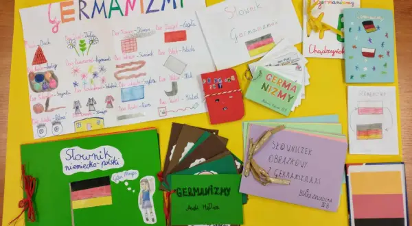 Kolorowa wystawa prac plastycznych i słowniczków na temat germanizmów w języku polskim.
