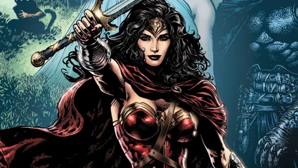 Wonder Woman z mieczem wzniesionym do góry, w czerwonej pelerynie i zbroi.