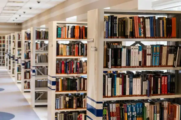 Rzędy regałów z książkami w bibliotece.